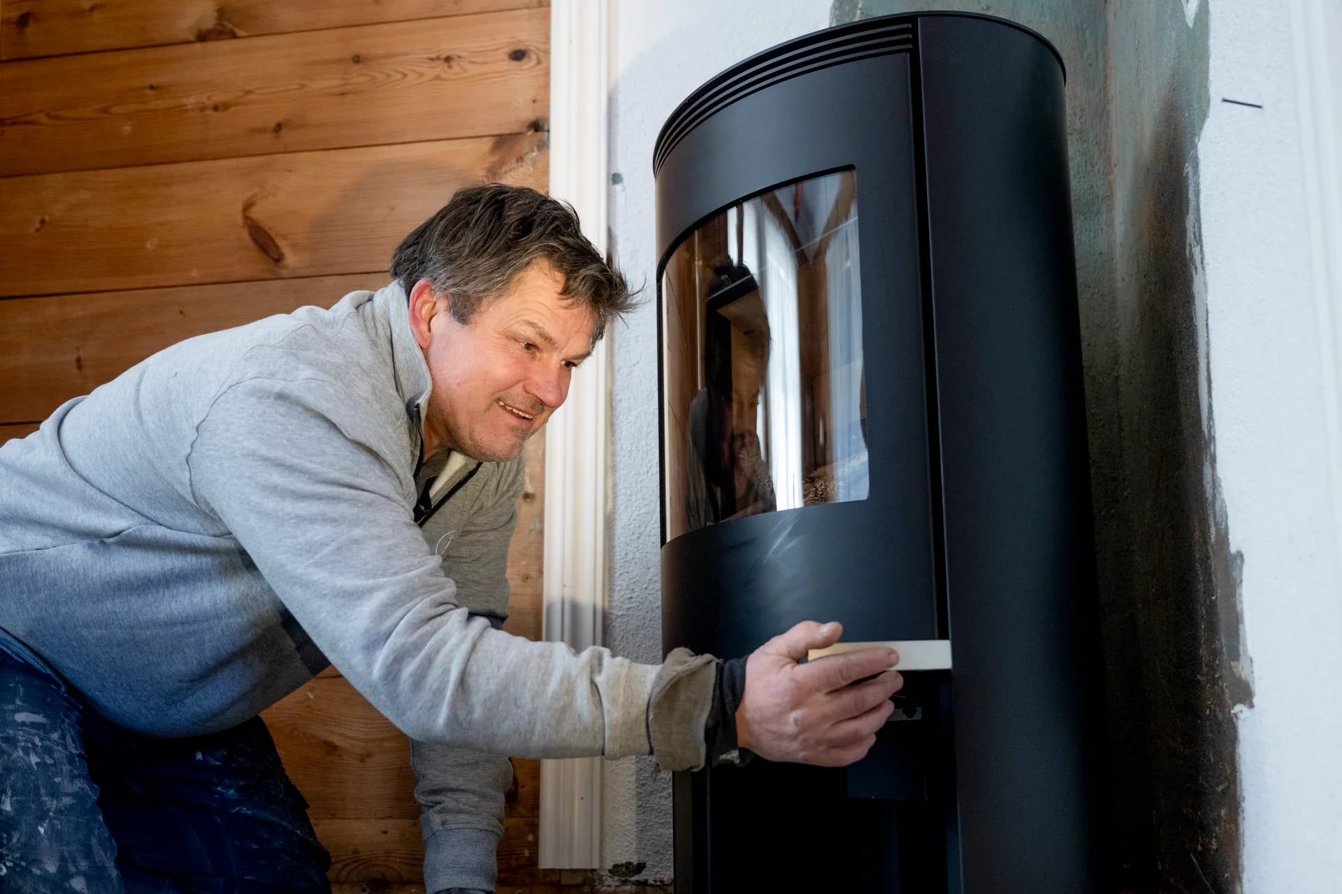 Sertifisert montør justerer ovn inntil vegg